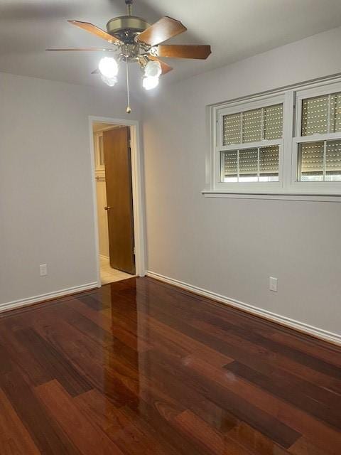 unfurnished room featuring baseboards, wood finished floors, and a ceiling fan