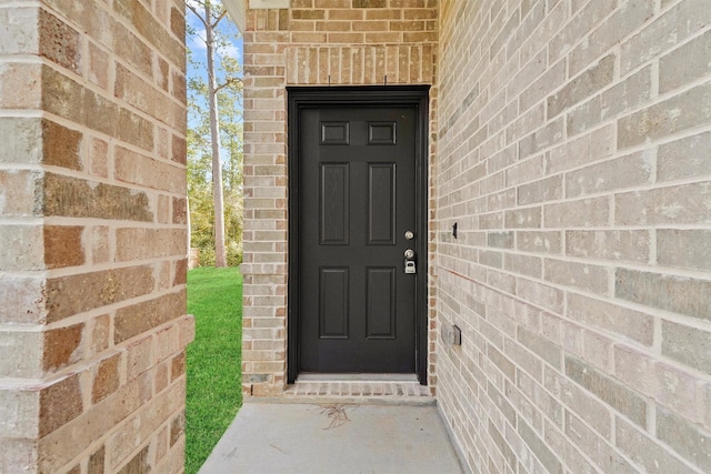 view of exterior entry with brick siding