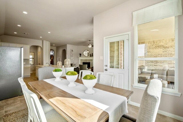 dining area with visible vents, baseboards, recessed lighting, a fireplace, and arched walkways