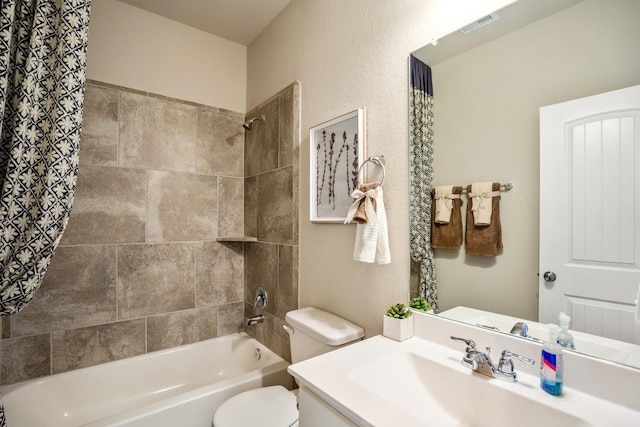 bathroom featuring visible vents, toilet, vanity, and shower / tub combination