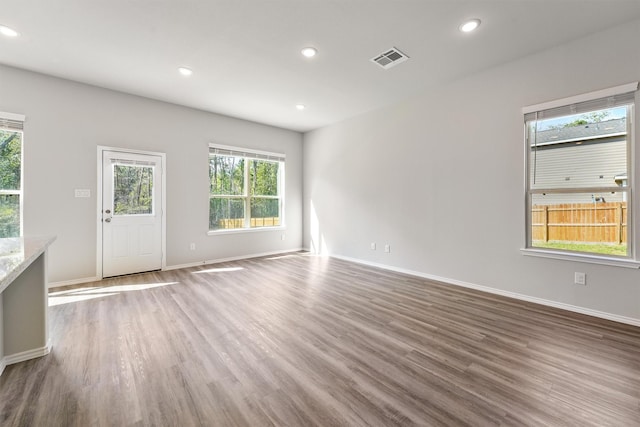 unfurnished living room with wood finished floors, recessed lighting, visible vents, and a wealth of natural light