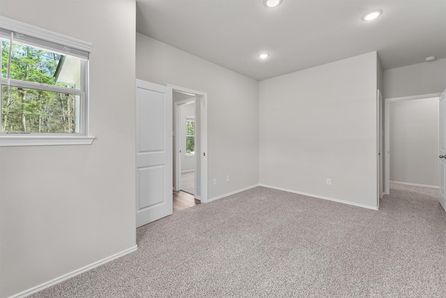 empty room featuring recessed lighting, baseboards, and carpet