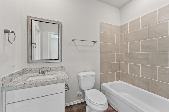 bathroom with toilet, wood finished floors, tub / shower combination, baseboards, and vanity