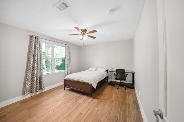 bedroom featuring visible vents, light wood-style flooring, baseboards, and ceiling fan