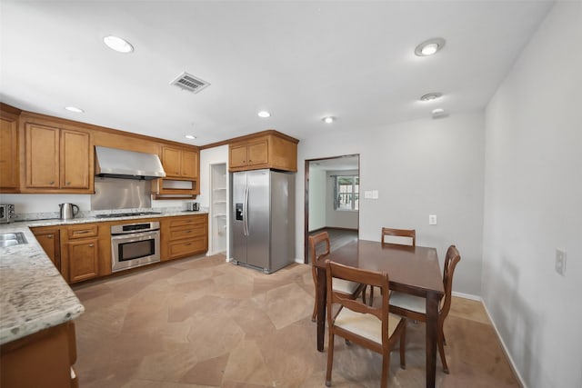 kitchen featuring brown cabinetry, visible vents, recessed lighting, stainless steel appliances, and wall chimney exhaust hood