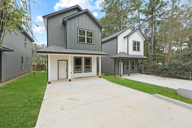 modern inspired farmhouse with covered porch, board and batten siding, a front lawn, and fence