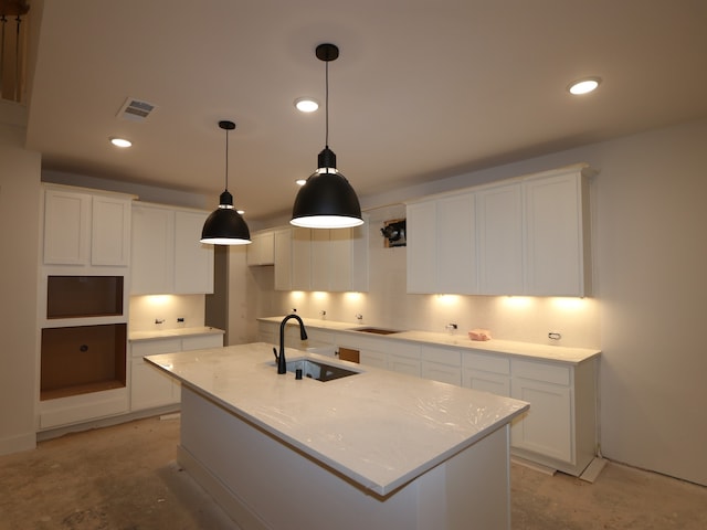 8518 Pier Cove Dr, Cypress, TX 77433 - kitchen featuring unfinished concrete floors, a kitchen island with sink, white cabinets, and recessed lighting