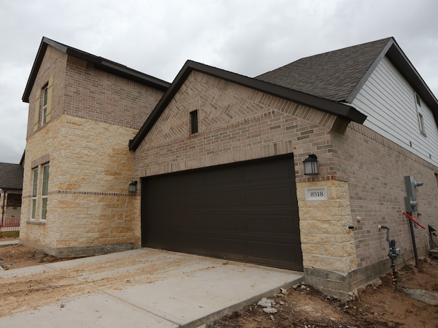 8518 Pier Cove Dr, Cypress, TX 77433 - view of home's exterior featuring brick siding, an attached garage, driveway, and a shingled roof
