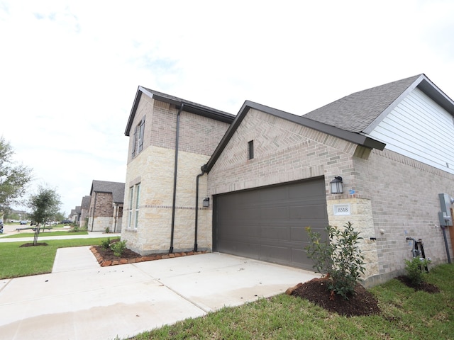 8518 Pier Cove Dr, Cypress, TX 77433 - view of home's exterior featuring stone siding, driveway, an attached garage, brick siding, and roof with shingles