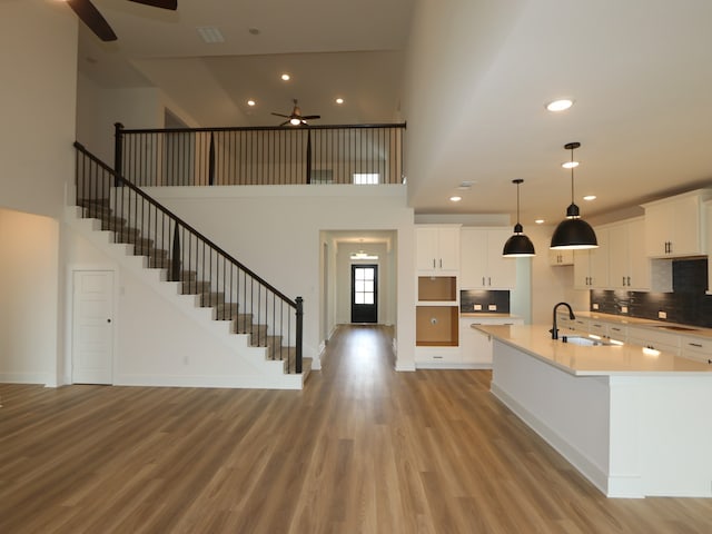 8518 Pier Cove Dr, Cypress, TX 77433 - kitchen featuring ceiling fan, light wood-type flooring, a towering ceiling, white cabinets, and recessed lighting