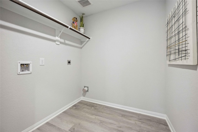 laundry area featuring light wood finished floors, visible vents, baseboards, laundry area, and electric dryer hookup