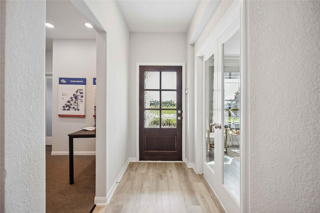 entrance foyer featuring baseboards, light wood-style flooring, and a textured wall