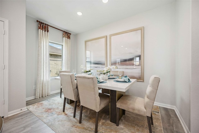 dining area with baseboards and wood finished floors