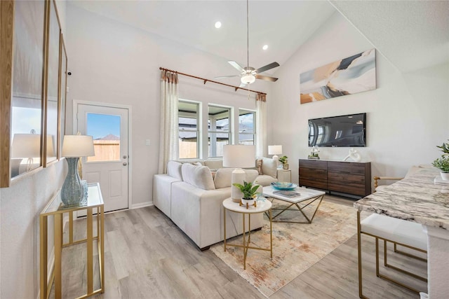 living room featuring recessed lighting, light wood-style floors, ceiling fan, and high vaulted ceiling