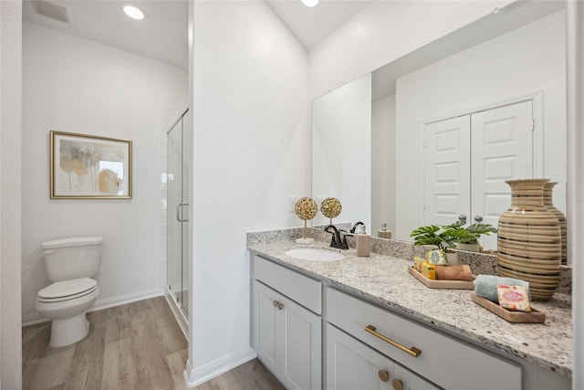 full bathroom with vanity, wood finished floors, visible vents, a shower stall, and toilet