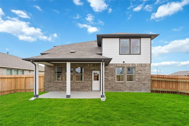 back of house with a yard, a patio, brick siding, and a fenced backyard