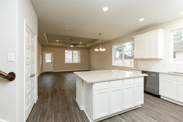 kitchen featuring visible vents, a raised ceiling, dishwasher, and dark wood finished floors