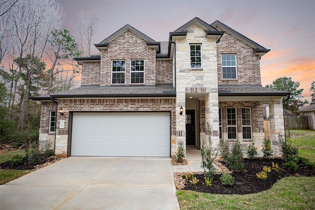 view of front of house featuring brick siding, stone siding, and concrete driveway