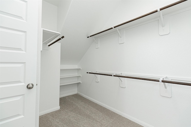 walk in closet featuring light colored carpet