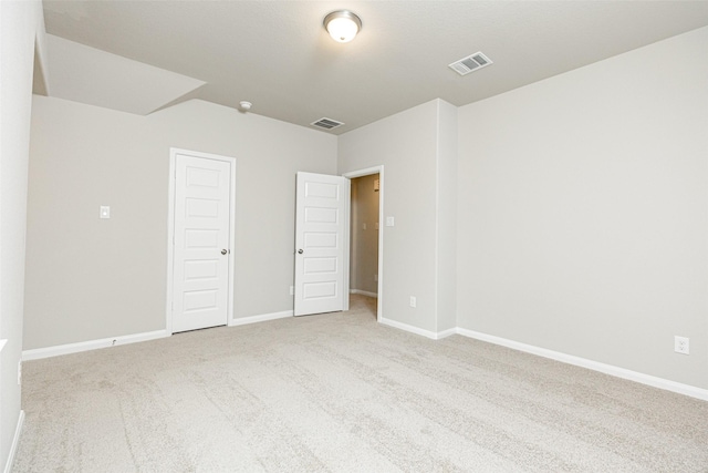 carpeted spare room with visible vents and baseboards