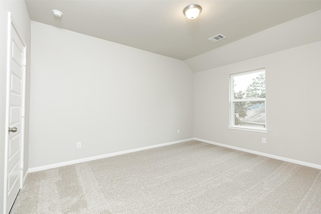 empty room with baseboards, visible vents, light carpet, and lofted ceiling