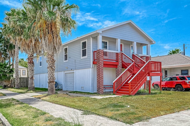 view of front of property featuring a garage, a porch, stairs, and a front yard