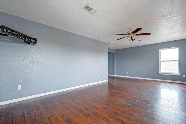 empty room featuring visible vents, a ceiling fan, baseboards, and hardwood / wood-style floors