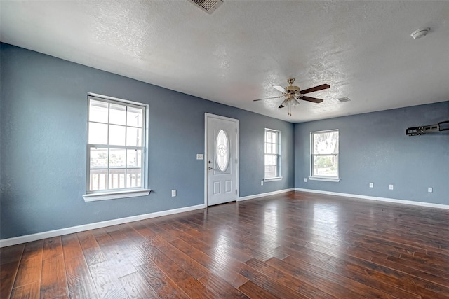 foyer entrance featuring visible vents, a textured ceiling, baseboards, and hardwood / wood-style floors