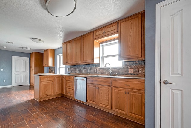 kitchen featuring dark wood finished floors, a sink, a wealth of natural light, and stainless steel dishwasher