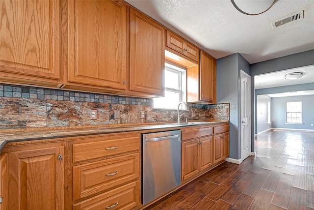 kitchen featuring a wealth of natural light, visible vents, a sink, tasteful backsplash, and stainless steel dishwasher