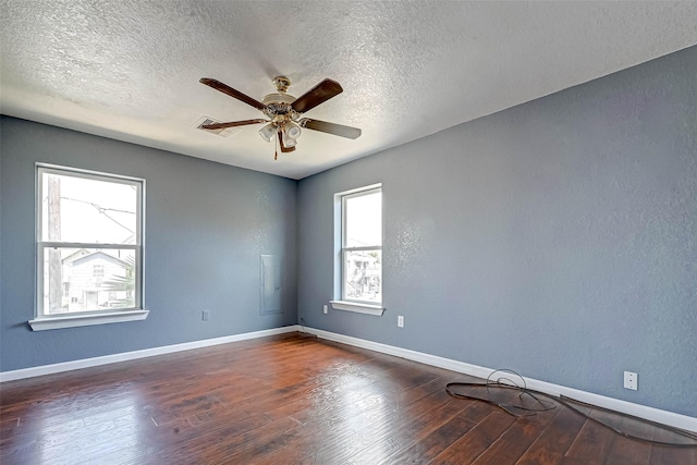 spare room with baseboards, a textured ceiling, ceiling fan, and dark wood-style flooring