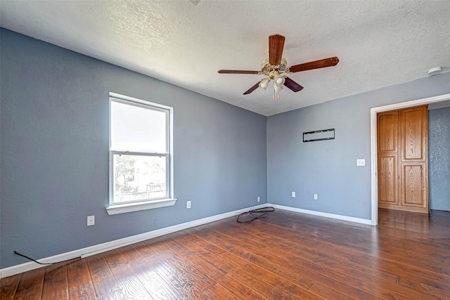 empty room with hardwood / wood-style floors, a ceiling fan, baseboards, and a textured ceiling