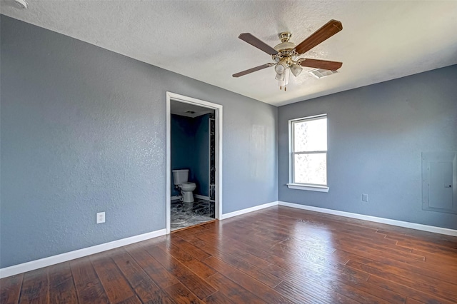 unfurnished bedroom with visible vents, hardwood / wood-style flooring, a textured ceiling, baseboards, and a textured wall