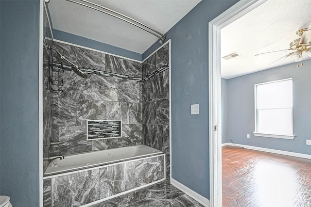 bathroom with a ceiling fan, baseboards, visible vents, tiled shower / bath combo, and marble finish floor