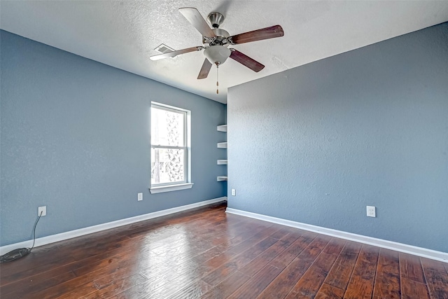 spare room with a ceiling fan, a textured ceiling, hardwood / wood-style floors, baseboards, and a textured wall