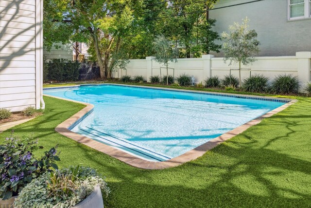 view of swimming pool with a fenced in pool, a lawn, and fence