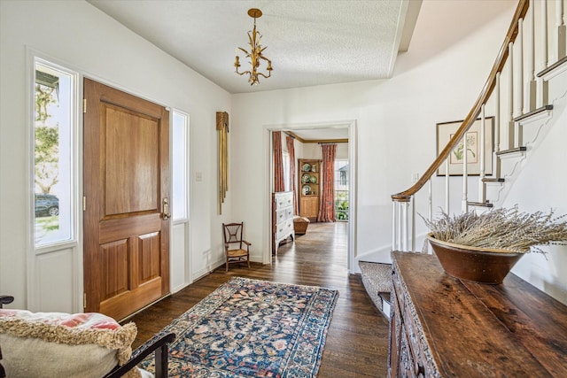 entrance foyer with stairs, dark wood-type flooring, a healthy amount of sunlight, and baseboards