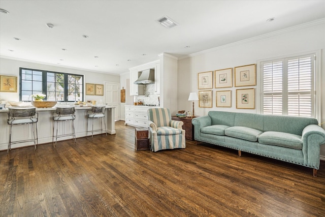 living area with dark wood-type flooring, recessed lighting, visible vents, and ornamental molding