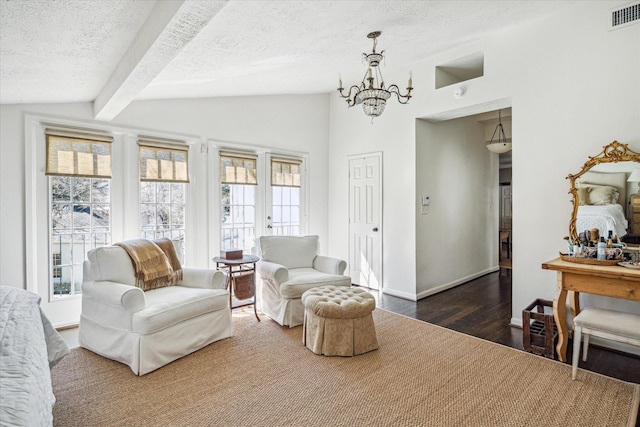 sitting room featuring vaulted ceiling with beams, wood finished floors, visible vents, and a textured ceiling