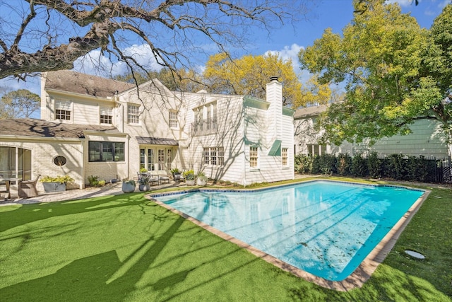 view of pool with a yard, a fenced in pool, and a patio