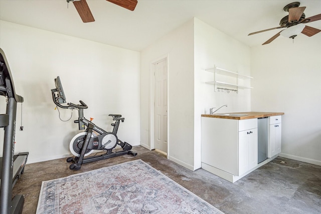 exercise room featuring a sink, baseboards, and ceiling fan