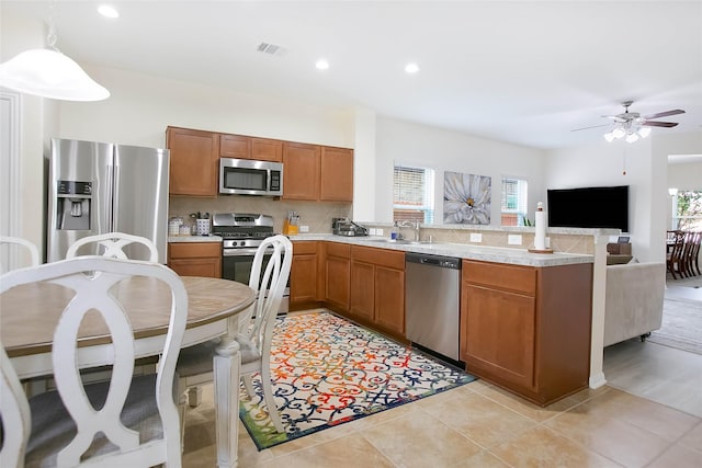 4918 Seaside Sparrow Ln, Baytown, TX 77521 - kitchen with a peninsula, a sink, light countertops, appliances with stainless steel finishes, and tasteful backsplash