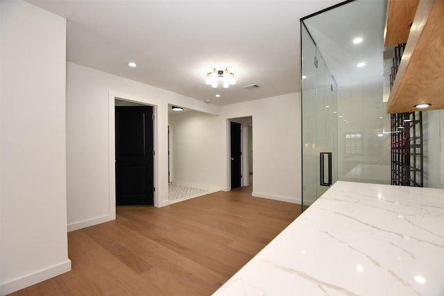 interior space featuring light stone counters, visible vents, baseboards, and light wood-style floors