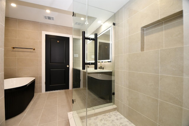 full bathroom featuring visible vents, a freestanding tub, recessed lighting, tile patterned flooring, and tile walls