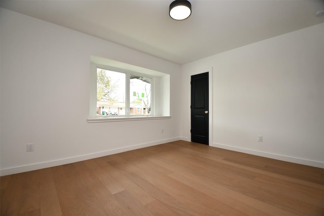 unfurnished room with light wood-style flooring and baseboards