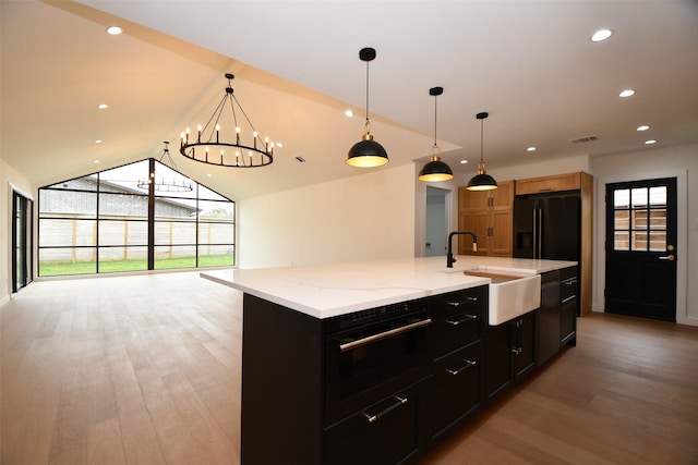 kitchen with light wood finished floors, visible vents, a wealth of natural light, black appliances, and a sink