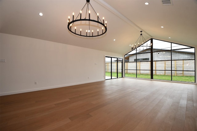 interior space featuring a notable chandelier, wood finished floors, visible vents, and baseboards