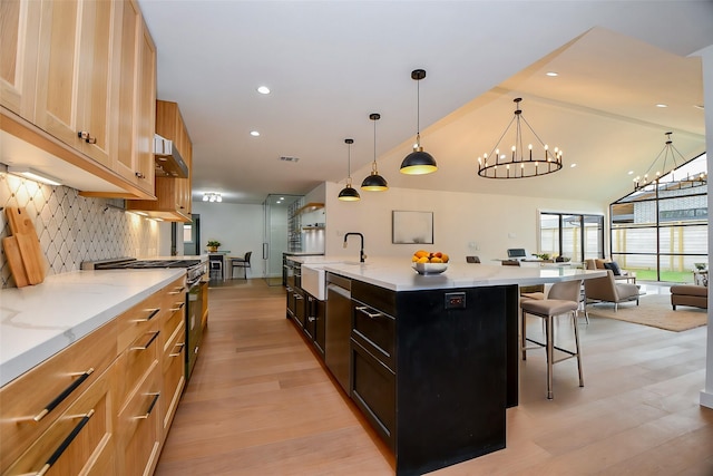 kitchen featuring stainless steel appliances, a kitchen bar, a notable chandelier, open floor plan, and backsplash