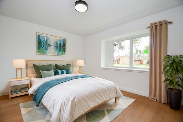 bedroom featuring baseboards and wood finished floors