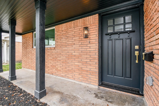 view of exterior entry with brick siding